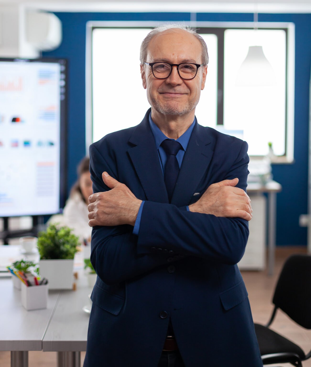 Portrait of succesful senior entrrepeneur in conference room smiling at camera with arms crossed. Manager working in professional start up financial business, modern company workplace ready for meeting.